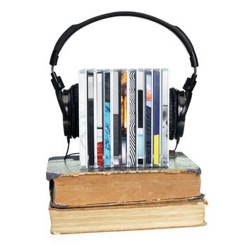 Stack of CDs with HI-Fi headphones and old books on white background