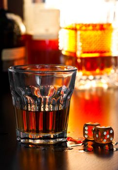 Glass of whiskey with dice, shallow DOF