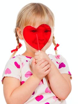 Cute little girl looking through big red heart shaped lolly pop candy
