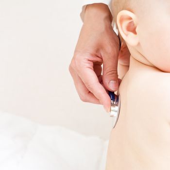 Children's doctor exams infant with stethoscope