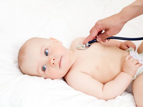 Children's doctor exams infant with stethoscope