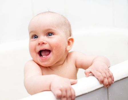 Cute little baby girl bathing with joy