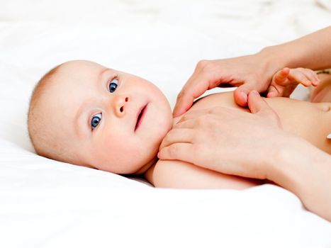 Masseuse massaging little baby girl, shallow focus