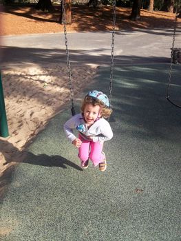 Having fun on playground in the park on on sunny afternoon.