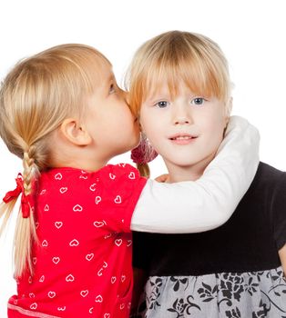 Portrait of little girl telling a secret to her friend over a white background