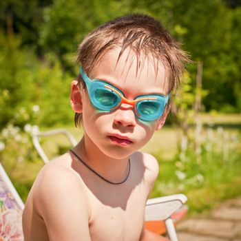 Portrait of a young boy wearing swimming googles outdoors