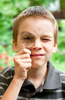 Young boy looking through hand magnifier, shallow DOF