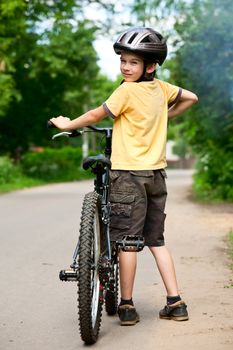 Young boy standing with bicycle, shallow dof