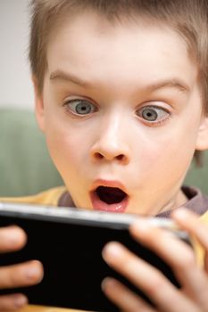 Young boy playing handheld game console