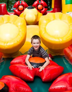 Young boy playing in inflatable playground