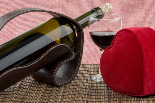 Bottle of wine, glass and red heart shaped gift box