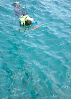 Active man diving snorkeling take photo in clean ocean on summer vacation at Chang island, Thailand