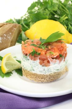 a slice of bread with herb cream and salmon tartare