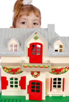 Little girl protruding behind toy house