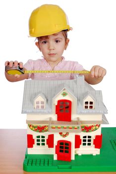 Little girl builder with toy house