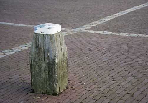 wooden bollard in the harbour to enter boat with ropes
