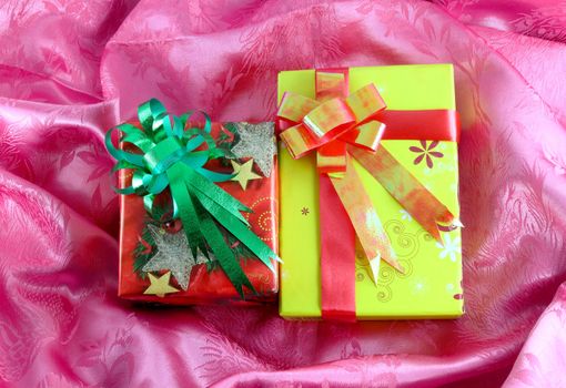 red and yellow gift box with ribbon on pink satin