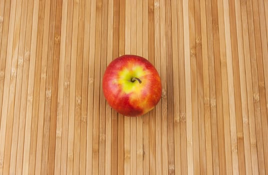 red apple lying on a bamboo napkin