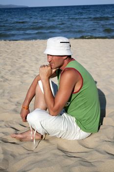 Portrait of a young man in a contemplative mood isolated at the beach