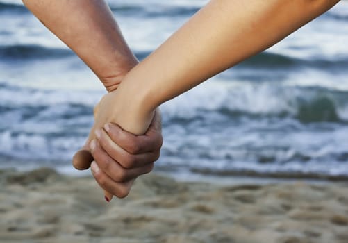 Love on the beach. Love concept.
Hand to hand love. Couple on beach.