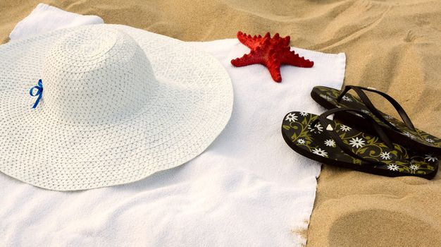 Towel, flip-flops, a hat and a starfish on the beach