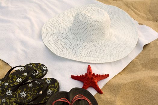 Towel, flip-flops, a hat and a starfish on the beach