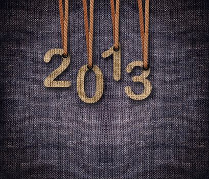 2013 numbers hunging by rope as puppeteer on sackcloth background.