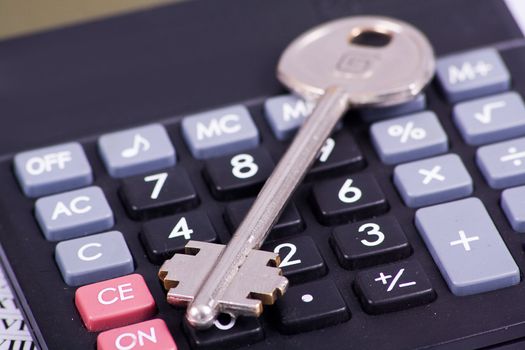 Black calculator with a key isolated on a white background