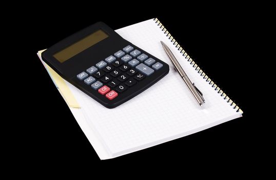 Calculator, pen and notebook on a black background