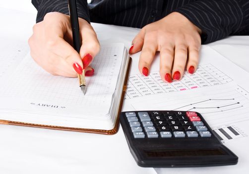 Business woman calculates and writes in the diary