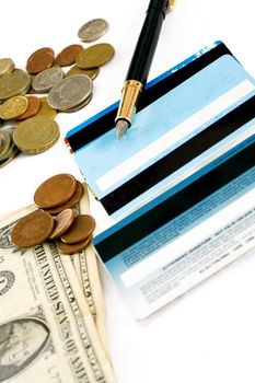 Bank cards, coins and dollars to the lying pen isolated on white background