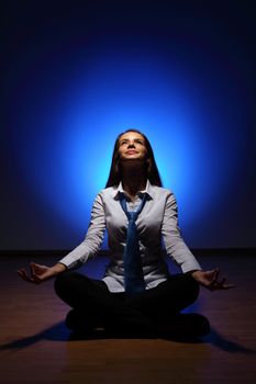 Young business woman sitting in asana lotus and meditating