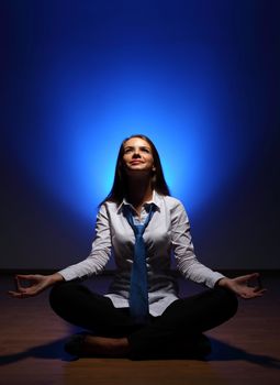 Young business woman sitting in asana lotus and meditating