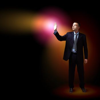 Young successful businessman holding a shining light in his hand as a symbol of success and advancement.