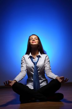 Young business woman sitting in asana lotus and meditating