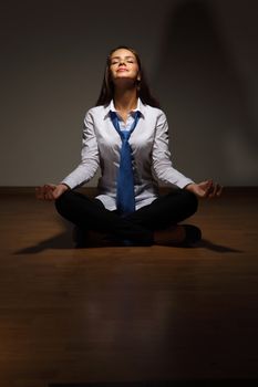 Young business woman sitting in asana lotus and meditating