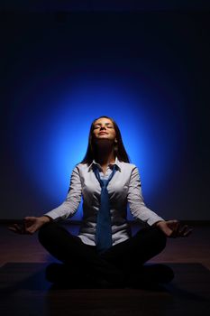 Young business woman sitting in asana lotus and meditating