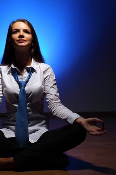 Young business woman sitting in asana lotus and meditating