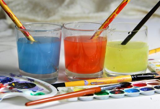 Art palette, watercolors, brushes and water 