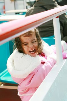 playful pretty little girl excited recreating in a ride on sail boat enjoying the spring