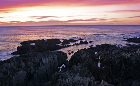 Onique rock formation on a beaqch at sunset
