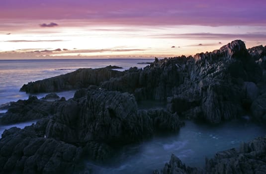 Onique rock formation on a beaqch at sunset