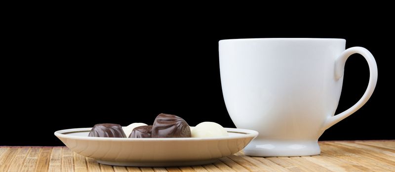 cup and saucer sweet candy isolated on black background