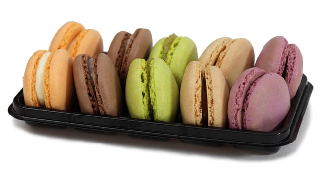 Tray with various macarons against a white background.