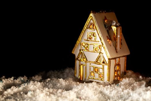 Little cozy toy house covered with artificial snow. Nice and warm background with copyspace for your greetings.