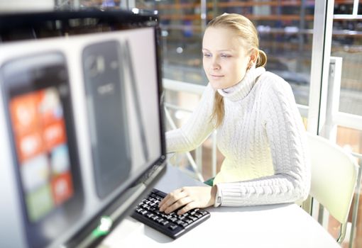 Young girl is choosing the smart phone in the online store.