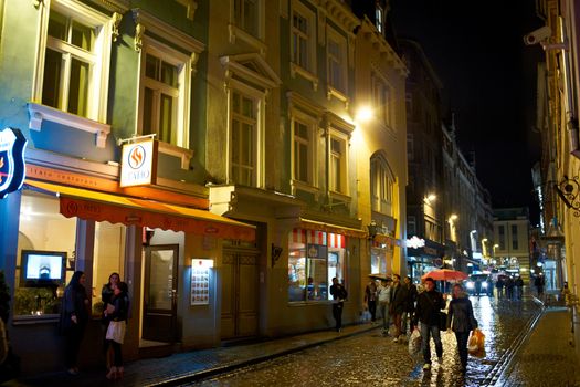 RIGA, LATVIA - OCTOBER 11:  People walking along street bars and restaurants in the evening in the old city of Riga, October 11, 2012 in Riga, Latvia.