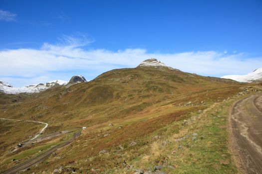 The picture shows the parts of a dirt road that goes over a mountain pass in Norway. It is best accessible by tractor or car with four-wheel drive