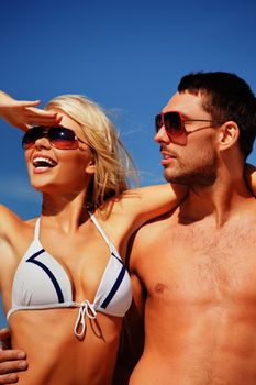 picture of happy couple in sunglasses on the beach.