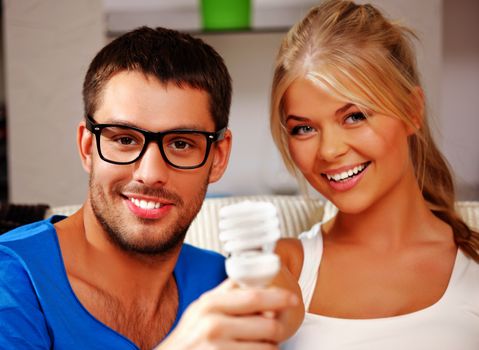 bright picture of happy couple holding energy saving bulb